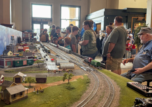 Crowd watching detailed model train layout